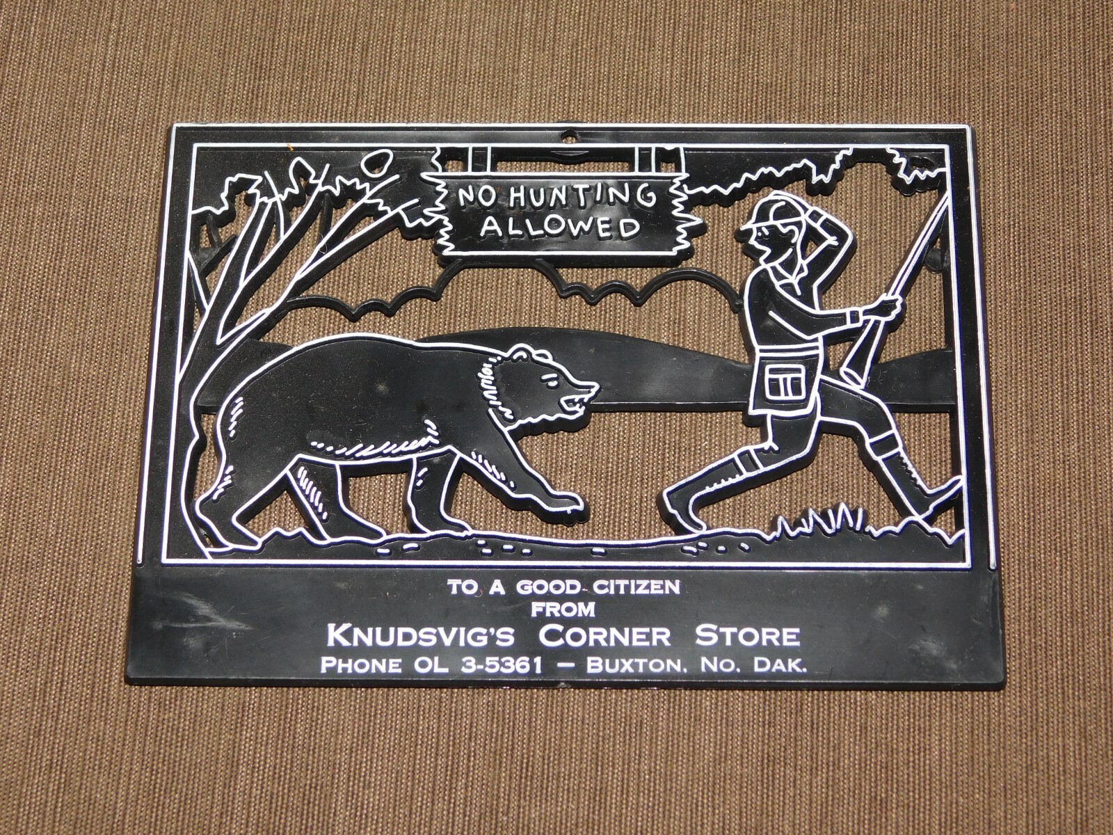VINTAGE KNUDSVIG’S CORNER STORE BUXTON N DAKOTA 6 X 4 1/2″ PLASTIC WALL AD SIGN