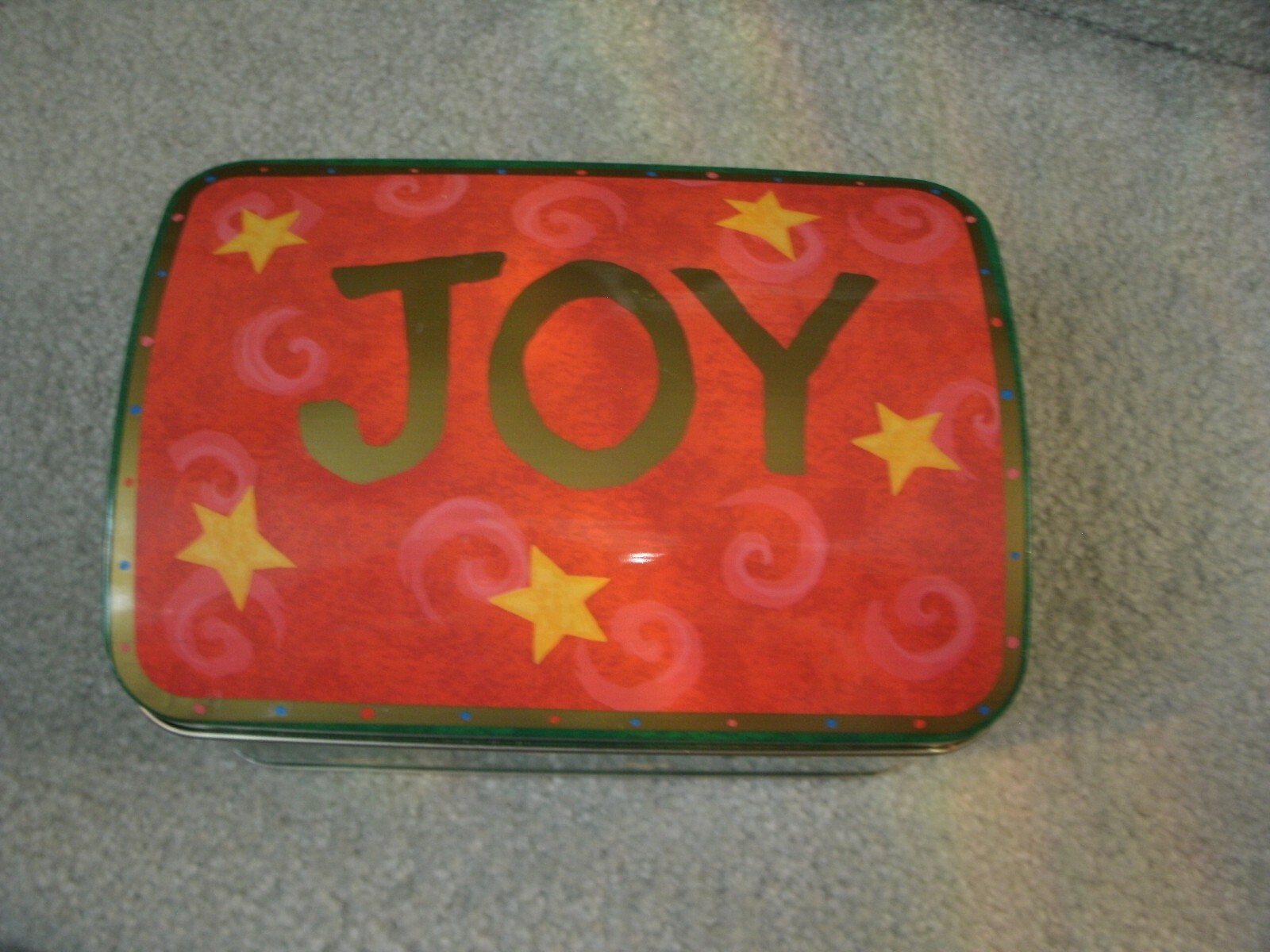 Used Tin Box in Green/Red/Yellow/JOY on the top of the lid w/Yellow Stars
