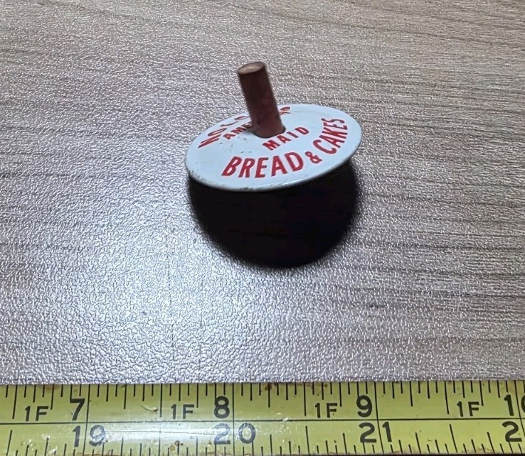 Vintage Nolde’s American Bread & Cakes Advertising Metal Spinning Top